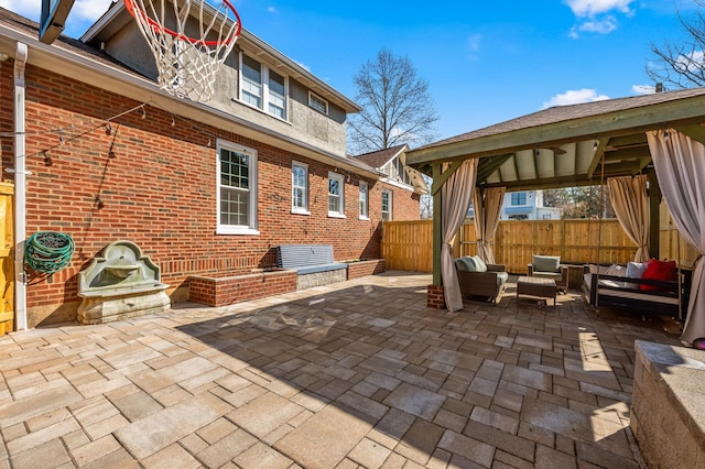 view of patio / terrace featuring a gazebo, an outdoor living space, and fence