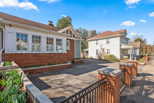 back of house with brick siding and a chimney