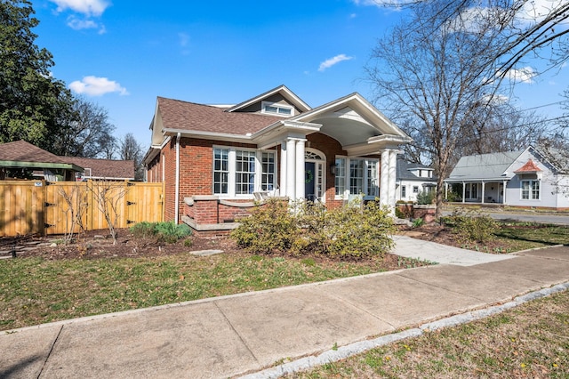 bungalow-style house featuring brick siding, a gate, and fence