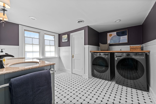 laundry room with washer and dryer, visible vents, wainscoting, and a sink