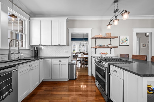 kitchen with dark wood-style floors, ornamental molding, a sink, white cabinets, and appliances with stainless steel finishes