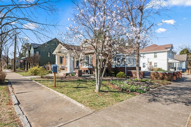 view of front facade with a front lawn, brick siding, and a residential view