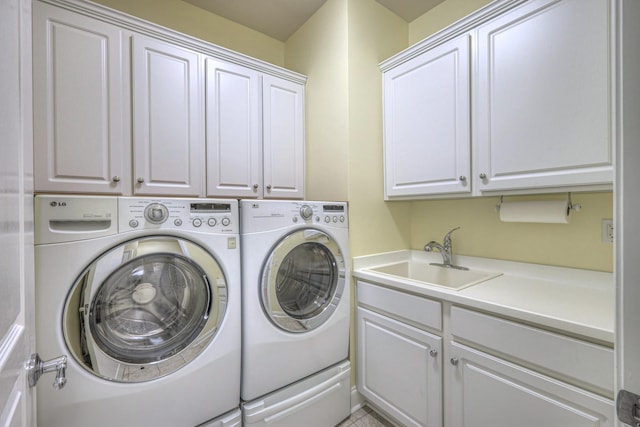 laundry area featuring separate washer and dryer, cabinet space, and a sink