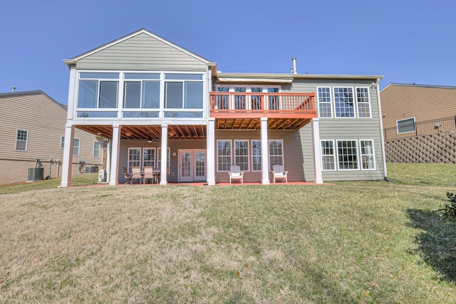 rear view of house with a deck, a patio, central AC, a yard, and french doors