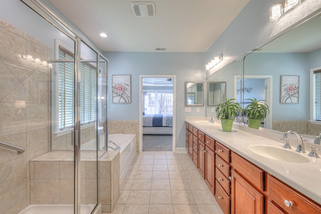 bathroom with tile patterned floors, double vanity, a shower stall, and a sink