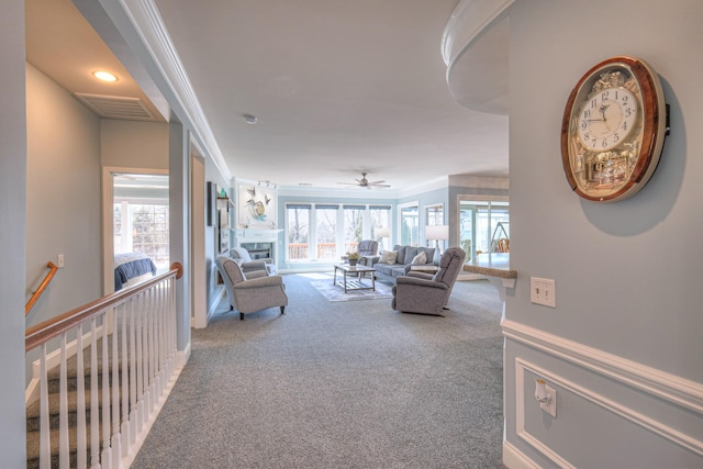 carpeted living room featuring visible vents, plenty of natural light, ornamental molding, and a fireplace