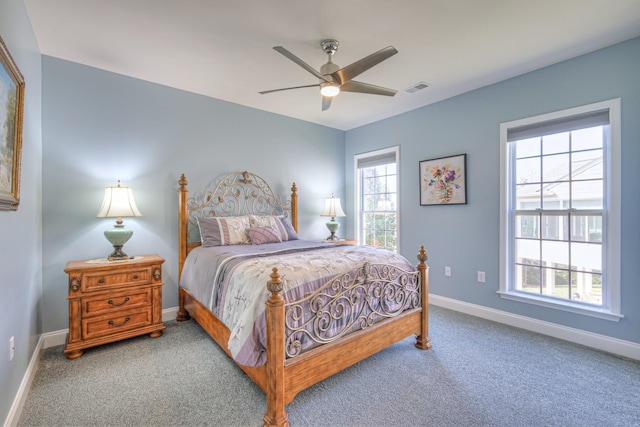 carpeted bedroom with a ceiling fan, baseboards, and visible vents