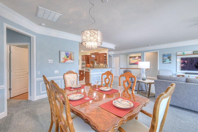 dining space featuring a wainscoted wall, light colored carpet, an inviting chandelier, and ornamental molding