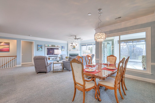 dining space featuring visible vents, baseboards, a fireplace, crown molding, and carpet flooring