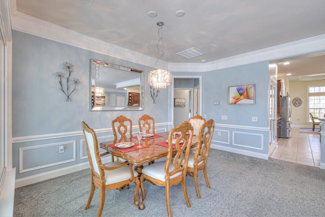 dining room featuring wainscoting, ornamental molding, carpet flooring, and a decorative wall