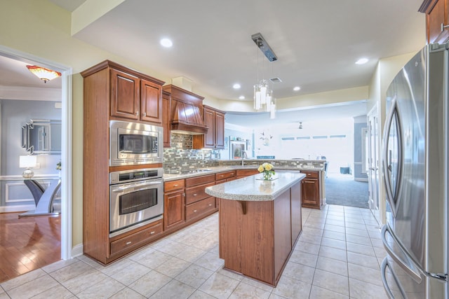 kitchen featuring a kitchen island, a peninsula, a sink, stainless steel appliances, and light countertops