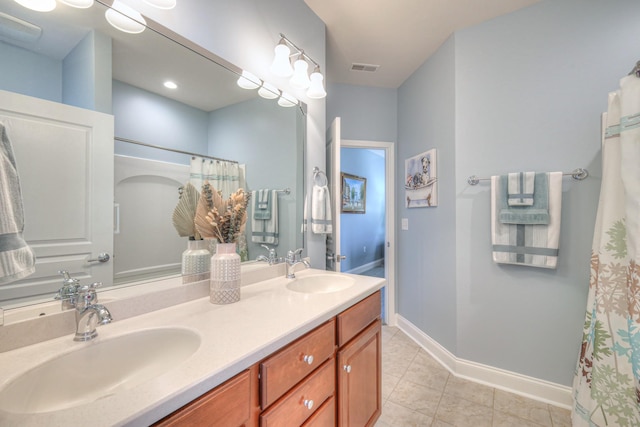 full bathroom with double vanity, visible vents, baseboards, and a sink