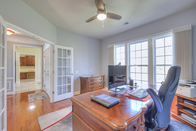 office featuring light wood-type flooring, visible vents, french doors, baseboards, and ceiling fan