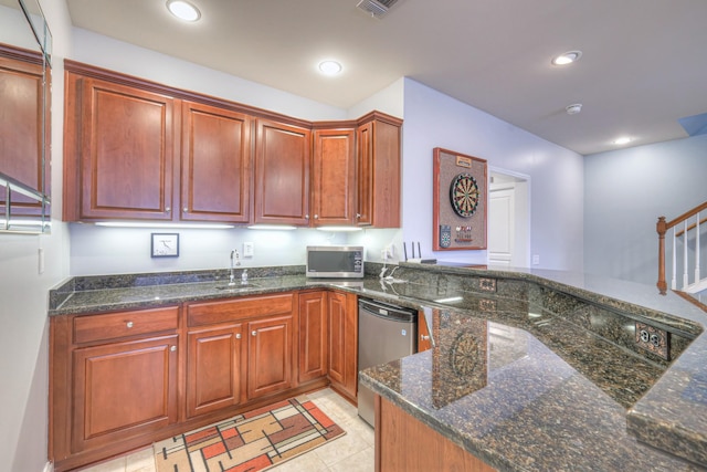 kitchen featuring dark stone countertops, recessed lighting, appliances with stainless steel finishes, and a sink