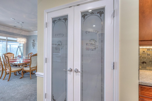 interior space featuring decorative backsplash, french doors, baseboards, and carpet floors