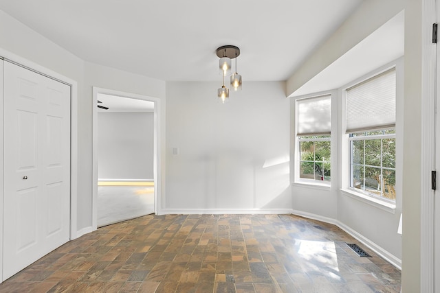 unfurnished room with visible vents and baseboards