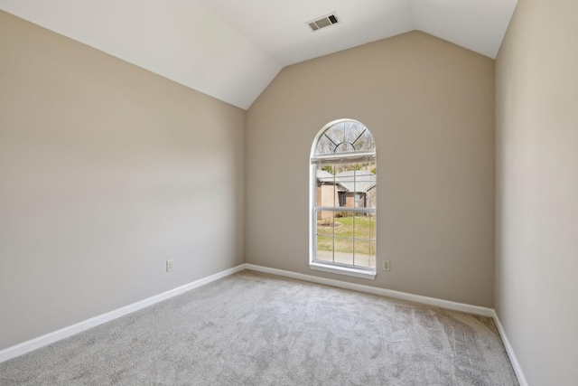 unfurnished room featuring vaulted ceiling, carpet, visible vents, and baseboards