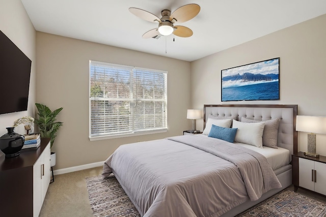 bedroom with a ceiling fan, baseboards, and light carpet