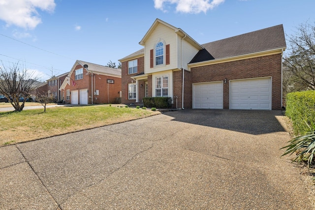 traditional-style house with a garage, a front lawn, brick siding, and driveway