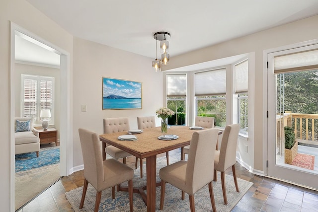 dining room featuring baseboards, a healthy amount of sunlight, and a chandelier