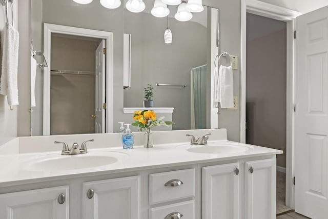 full bathroom with double vanity and a sink