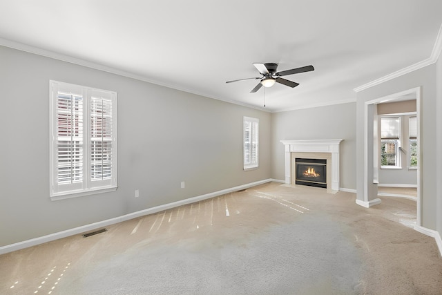 unfurnished living room with baseboards, visible vents, a fireplace with flush hearth, light carpet, and crown molding