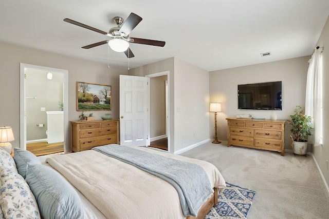 carpeted bedroom featuring visible vents, baseboards, ensuite bathroom, and a ceiling fan