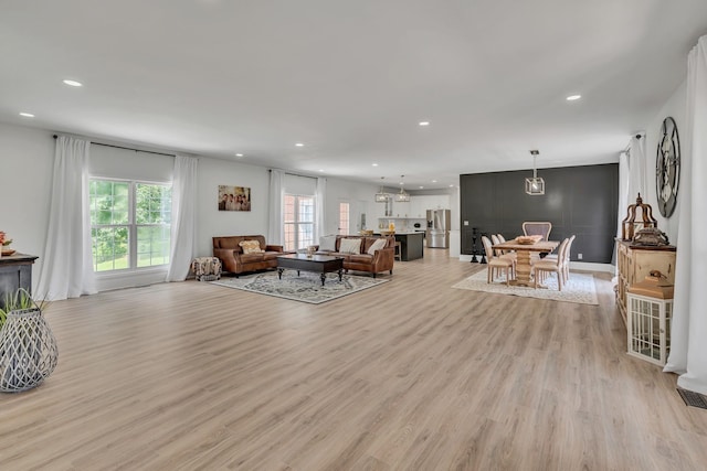 living area with recessed lighting, light wood-style floors, and a healthy amount of sunlight
