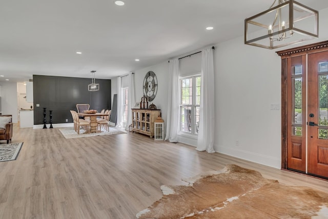 entrance foyer featuring recessed lighting, baseboards, an inviting chandelier, and light wood finished floors