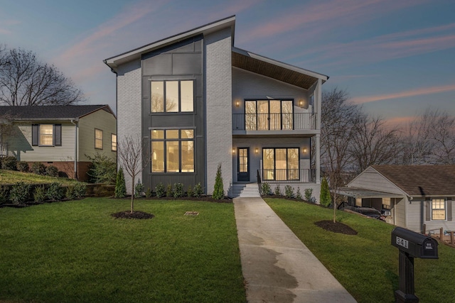 modern home featuring a yard, a balcony, and covered porch