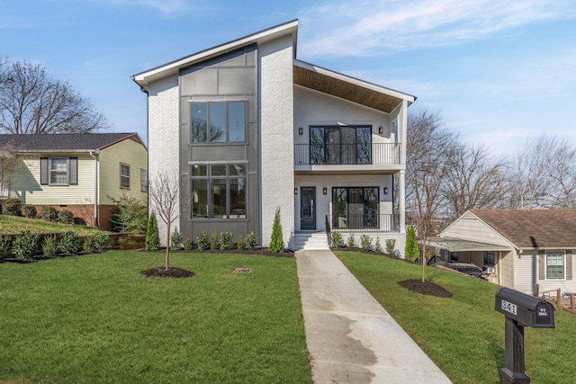 contemporary home featuring brick siding, a balcony, a porch, and a front lawn