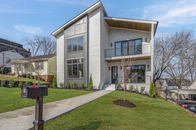 view of front facade with brick siding, a front yard, and a balcony