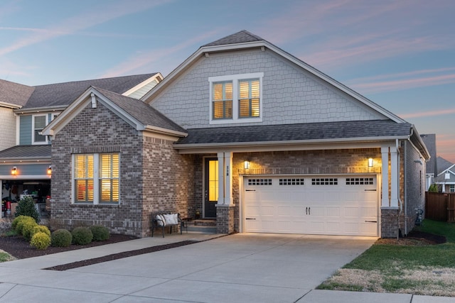 view of front of home featuring concrete driveway, brick siding, a garage, and roof with shingles