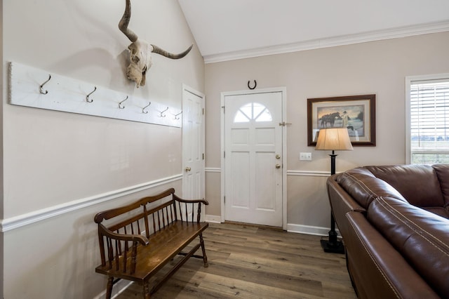 entrance foyer with vaulted ceiling, wood finished floors, baseboards, and ornamental molding