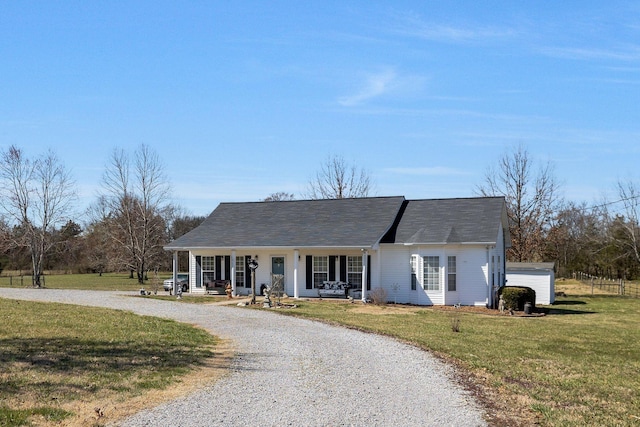 view of front facade with a front yard, covered porch, and driveway