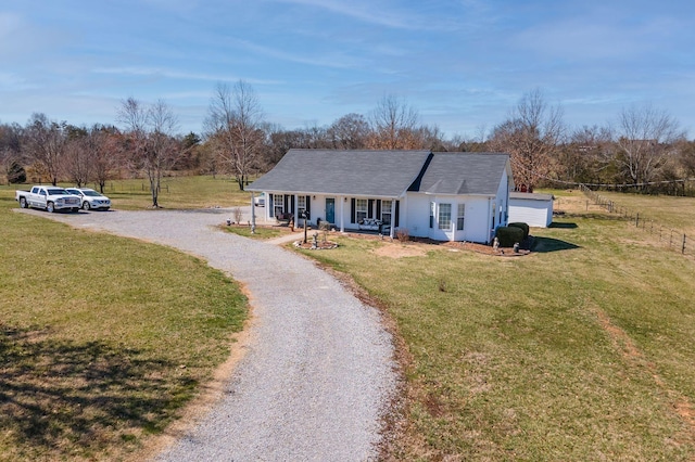 view of front of house featuring a porch, driveway, a front lawn, and fence