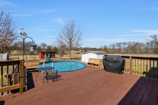 view of swimming pool with a deck, a storage shed, and an outbuilding