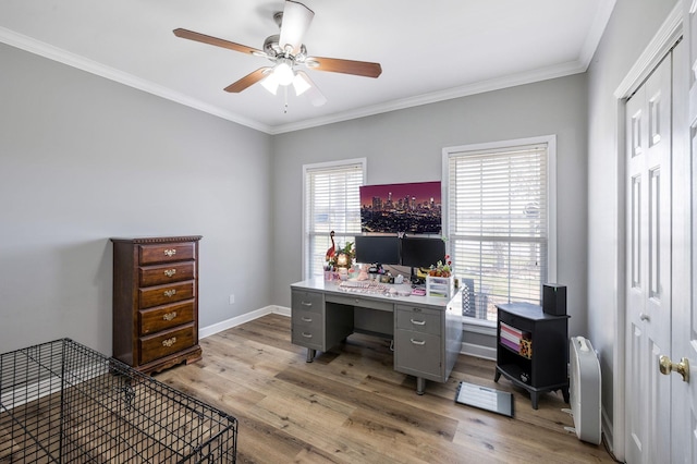 office space featuring light wood finished floors, ceiling fan, crown molding, and baseboards