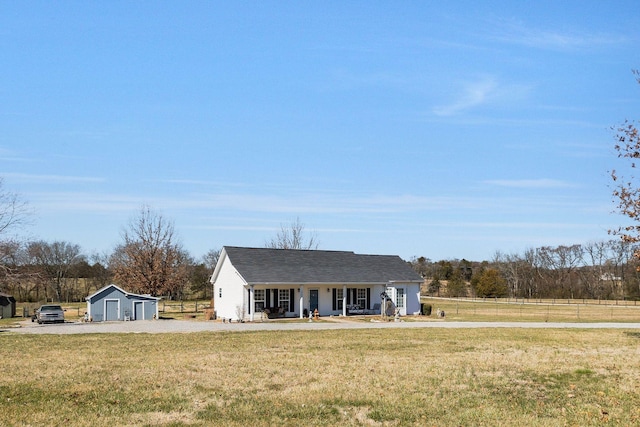 view of front facade with covered porch, an outdoor structure, a front lawn, and fence