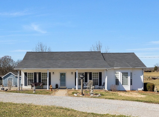 ranch-style home with gravel driveway and covered porch