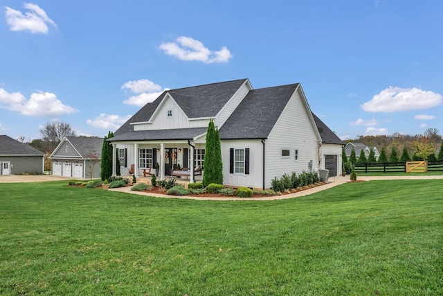 modern inspired farmhouse with fence, board and batten siding, covered porch, a front yard, and a garage