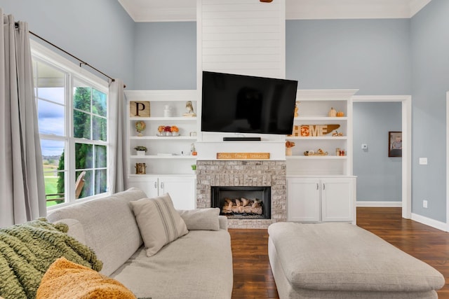 living room featuring baseboards, dark wood-type flooring, ornamental molding, and a fireplace