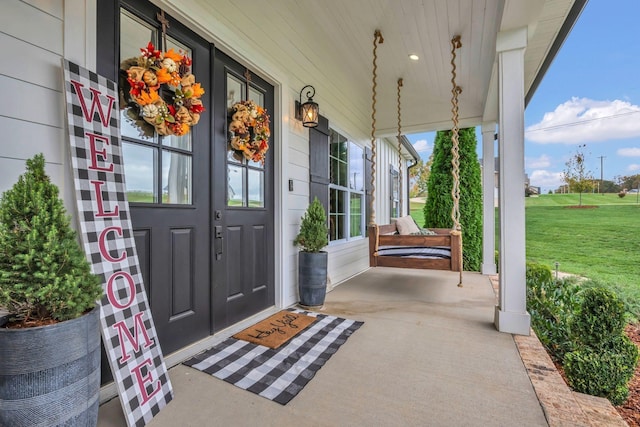 doorway to property with a yard and a porch