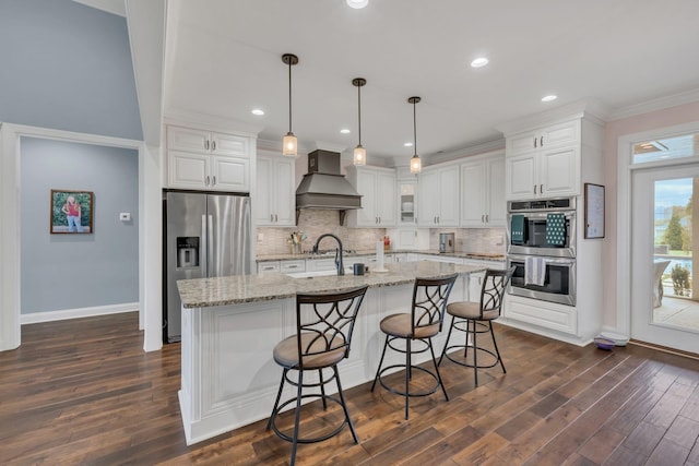 kitchen with decorative backsplash, appliances with stainless steel finishes, white cabinets, and custom range hood