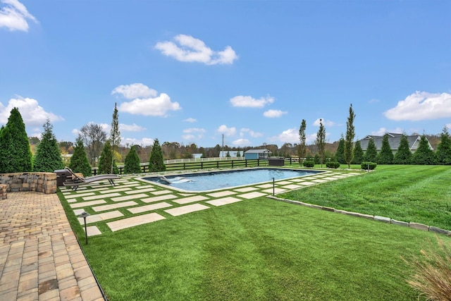 view of swimming pool with a lawn and fence