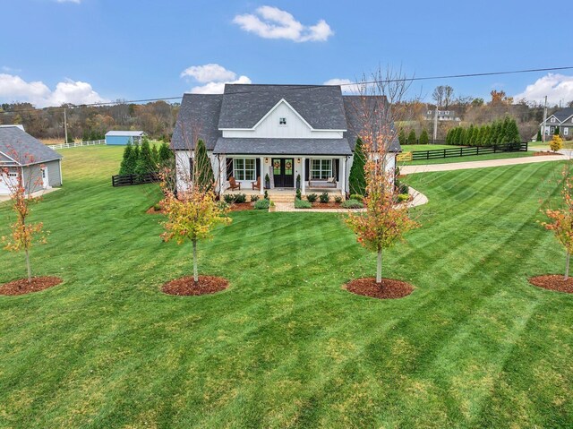 view of front of home with a front lawn, fence, and covered porch