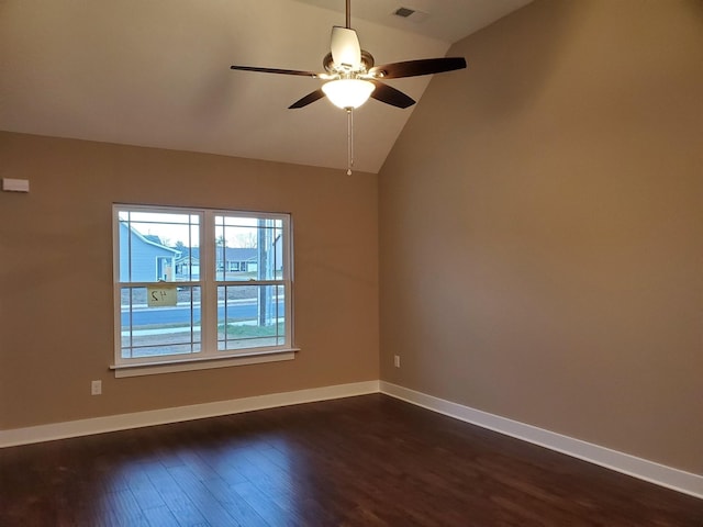 empty room with a ceiling fan, baseboards, visible vents, dark wood-style flooring, and vaulted ceiling