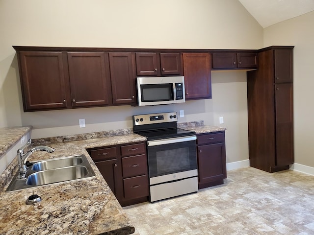 kitchen featuring vaulted ceiling, stainless steel appliances, light countertops, and a sink