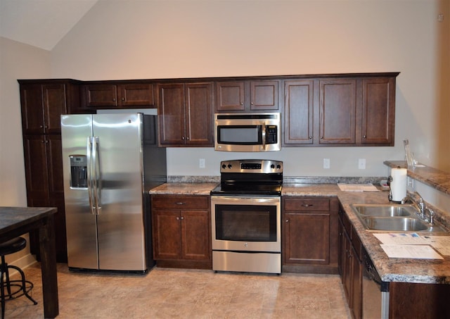 kitchen featuring a sink, dark brown cabinetry, vaulted ceiling, and stainless steel appliances