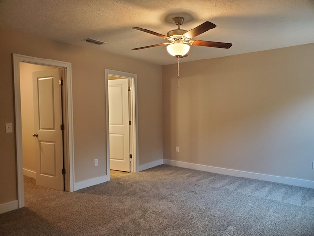 unfurnished bedroom featuring visible vents, a ceiling fan, a textured ceiling, carpet floors, and baseboards